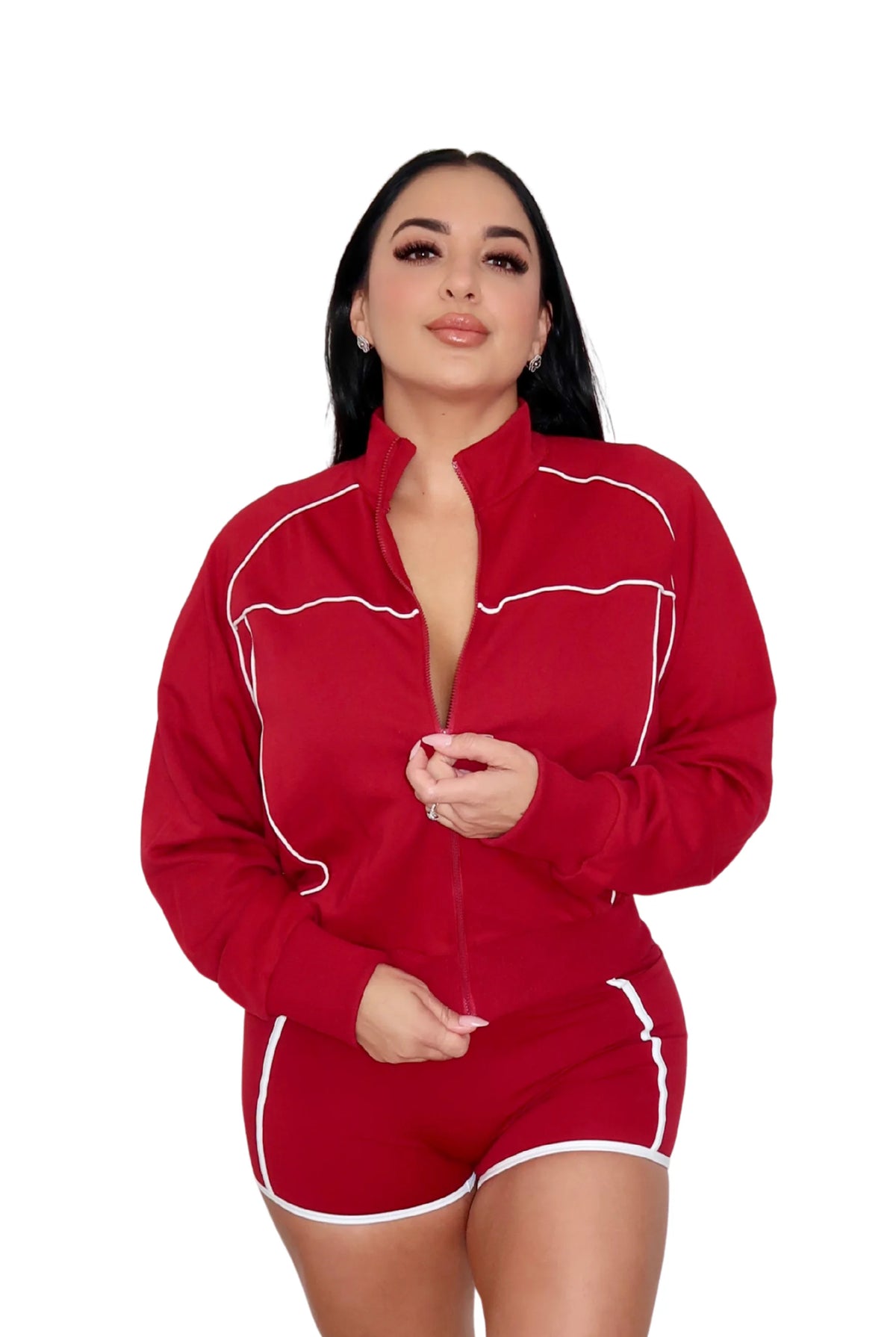 Woman wearing a red athletic outfit with a jacket, sports bra, and shorts on a white background