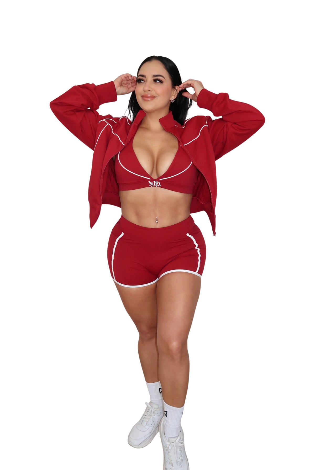 Woman wearing a red outfit with a matching jacket and shorts on a white background