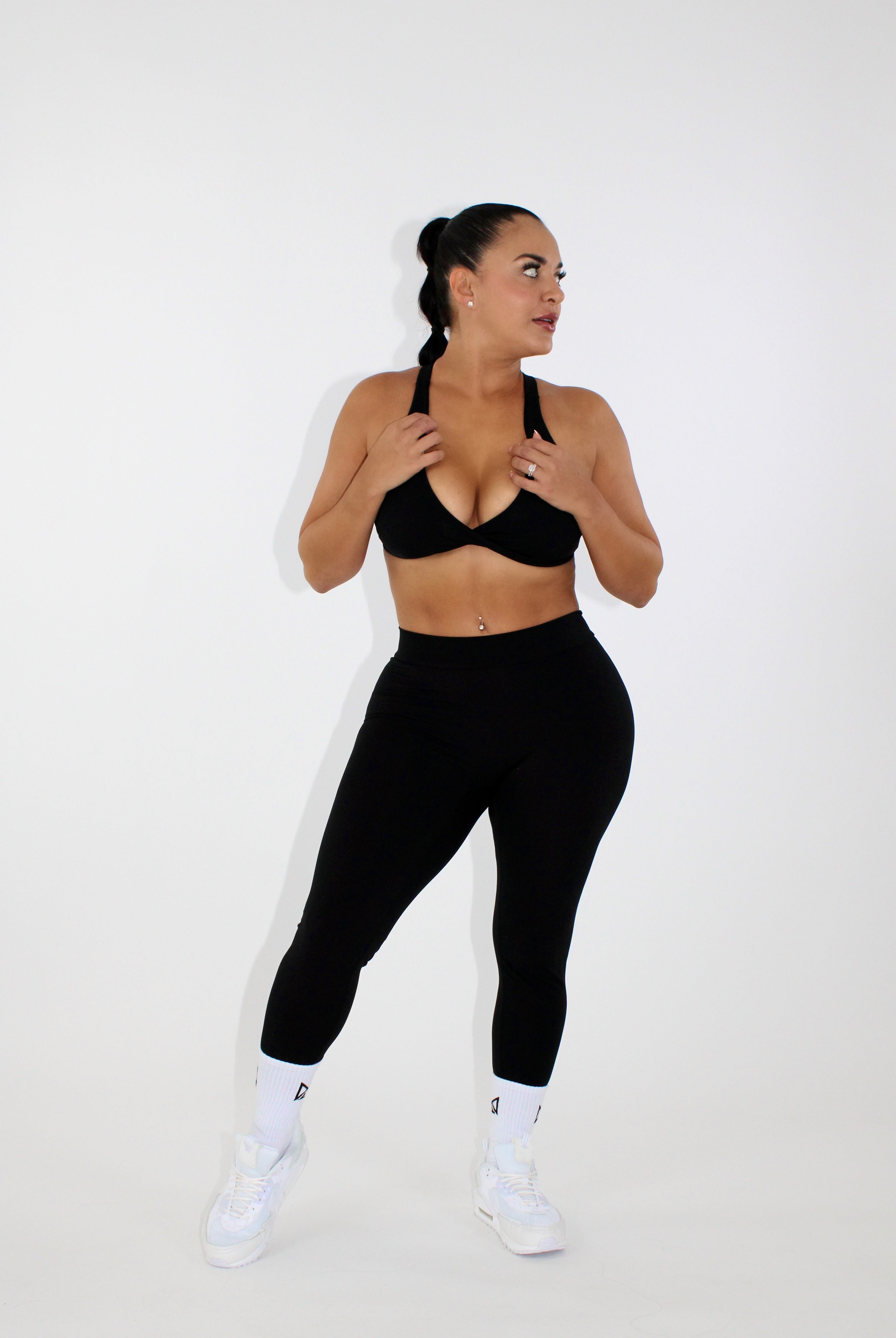 Woman wearing black leggings and a black sports bra
