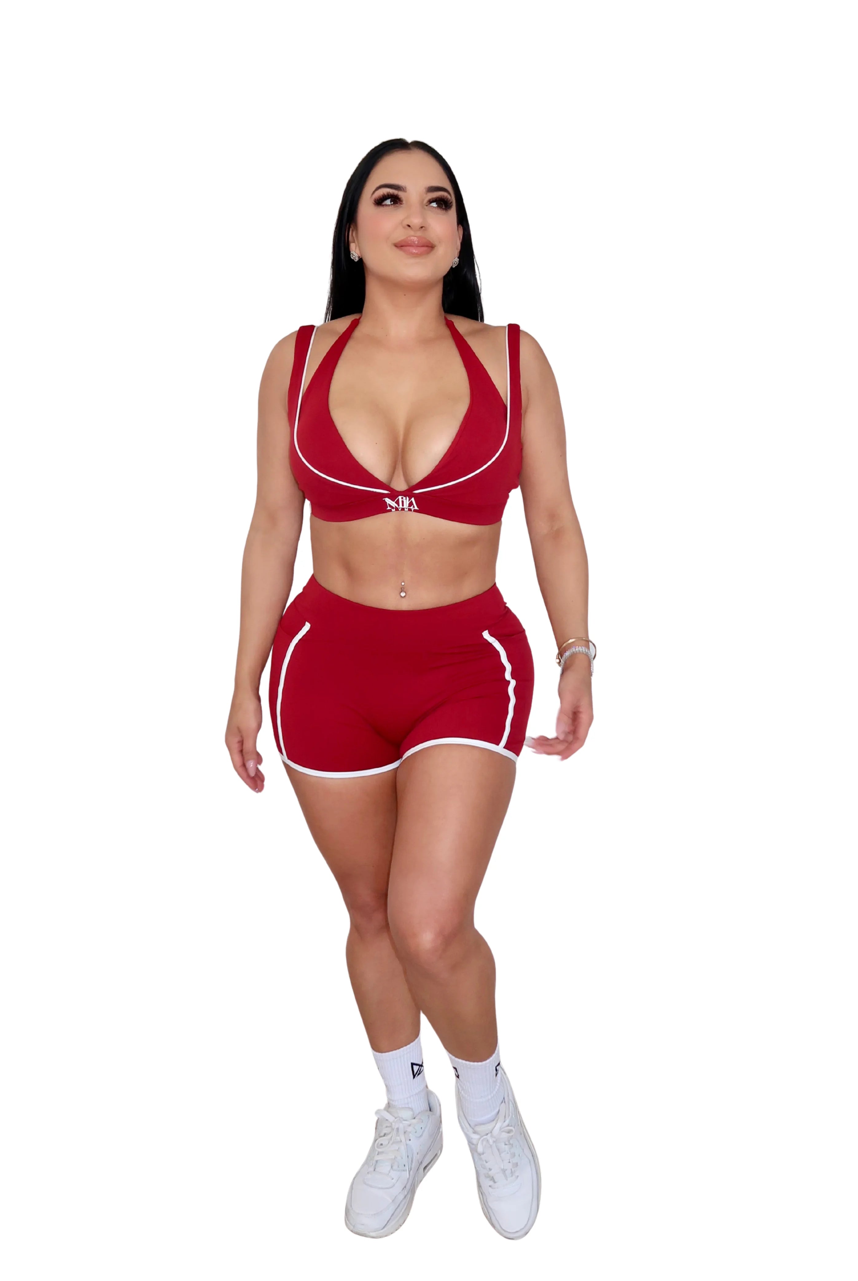 Woman wearing a red sports outfit with white accents on a white background