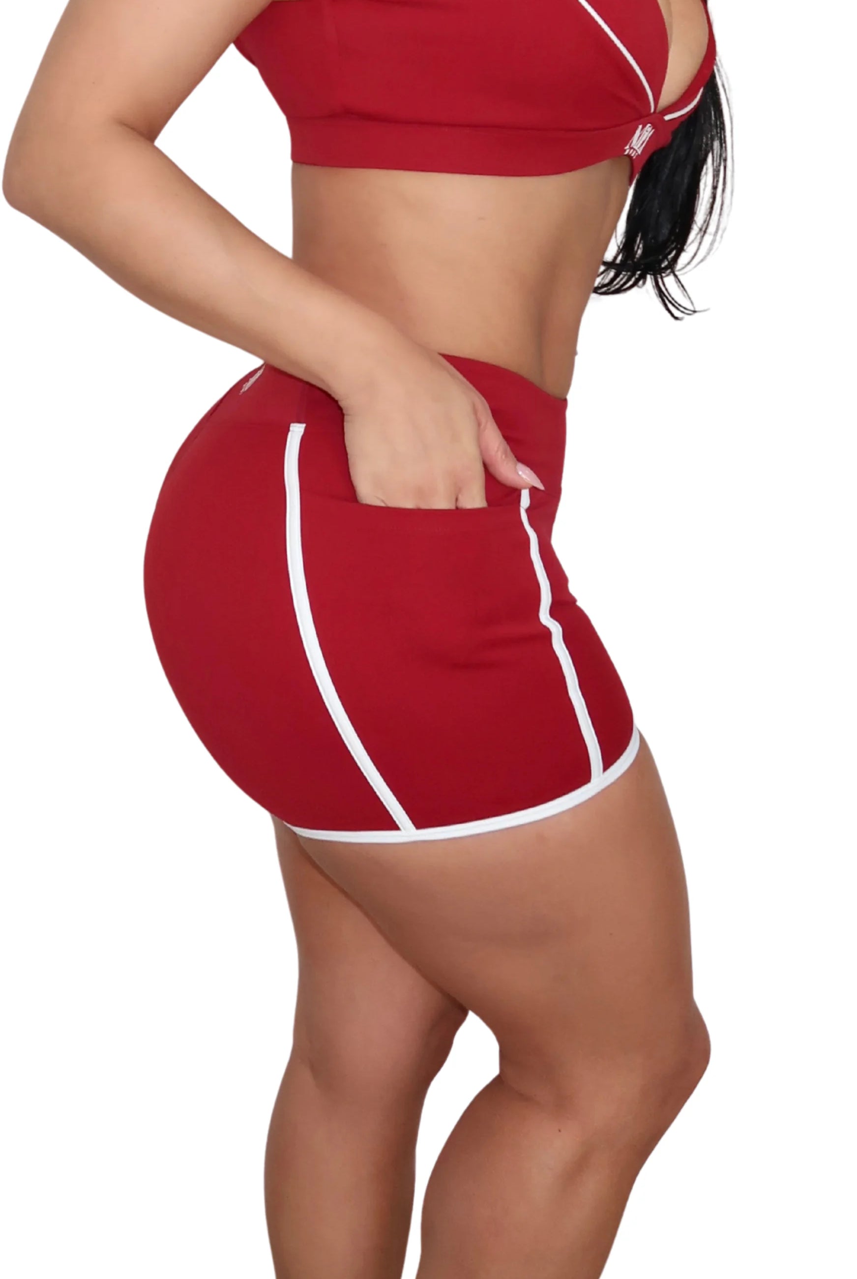 Woman wearing a red athletic outfit with white accents on a white background