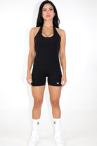 Women wearing a black MILA MVMT Sportswear One-Piece Gym Workout Romper Onesie - facing the front