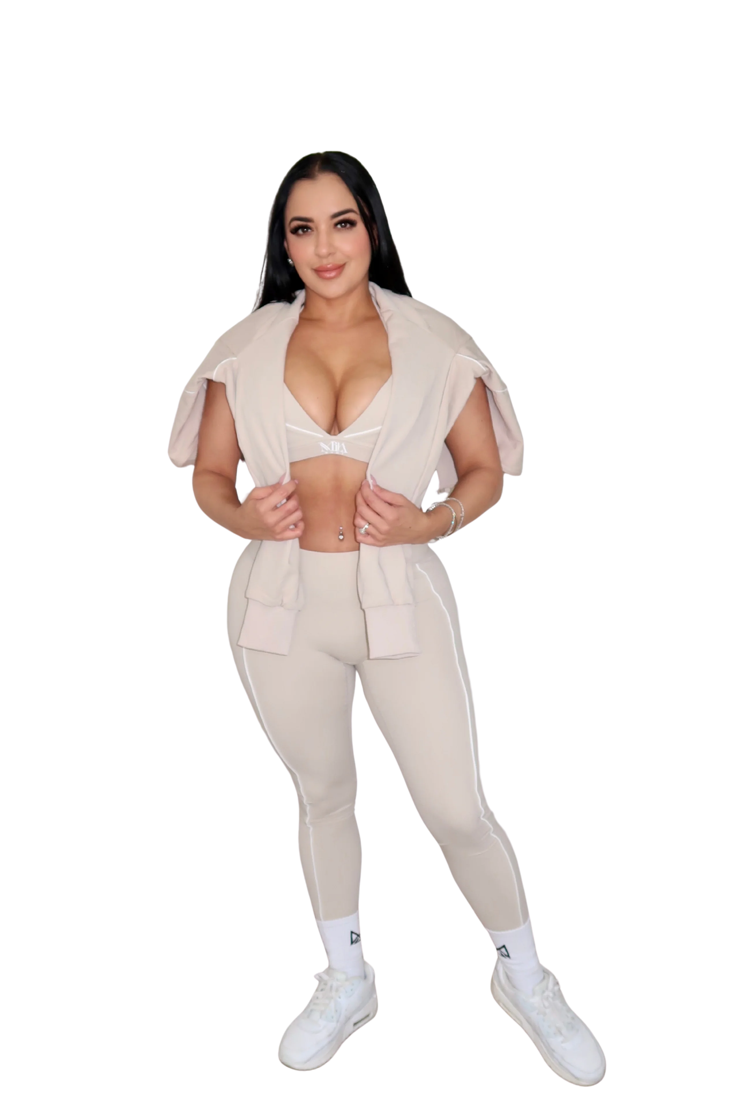 Woman in beige athletic wear posing.