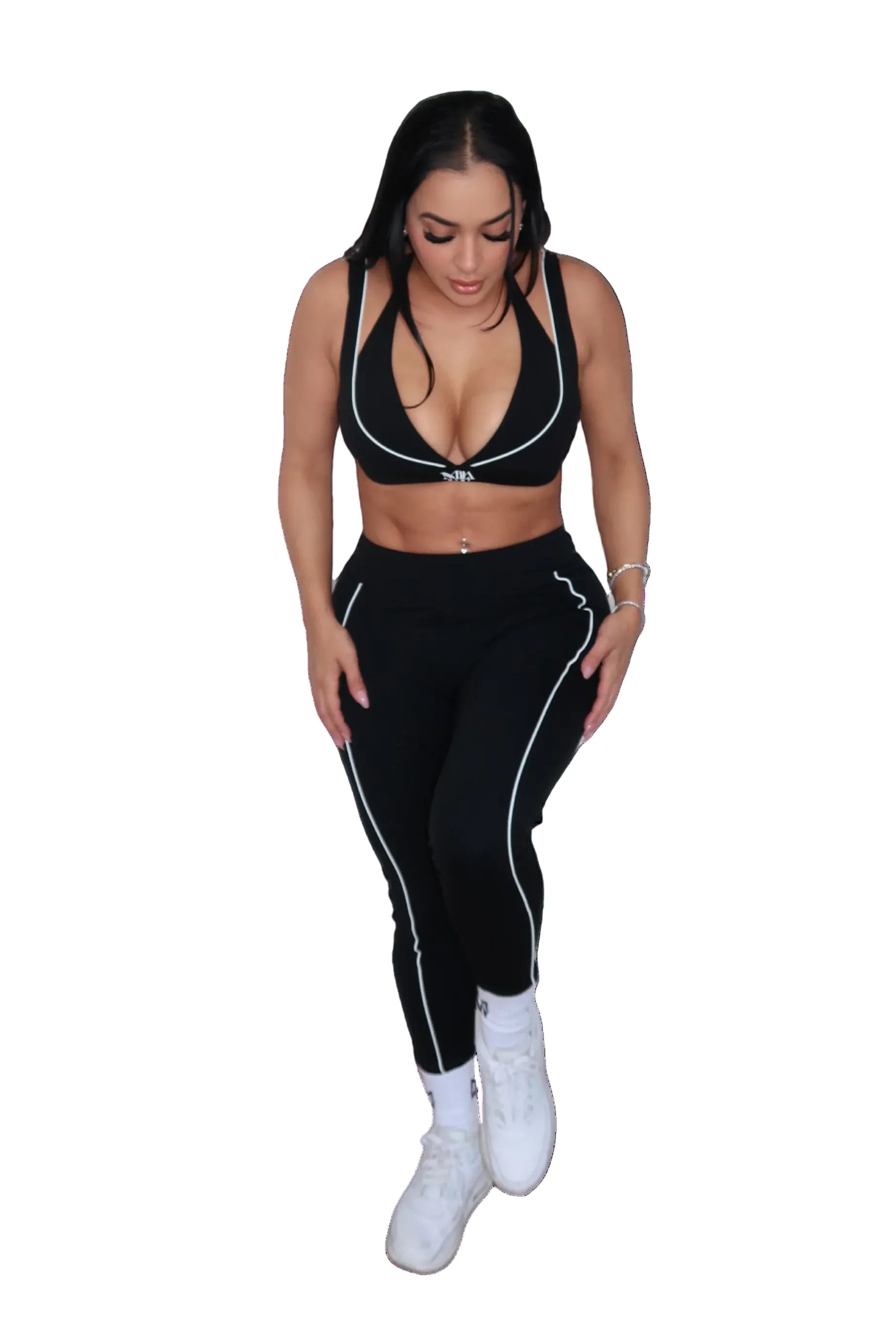 Woman wearing a black sports bra and leggings set on a white background