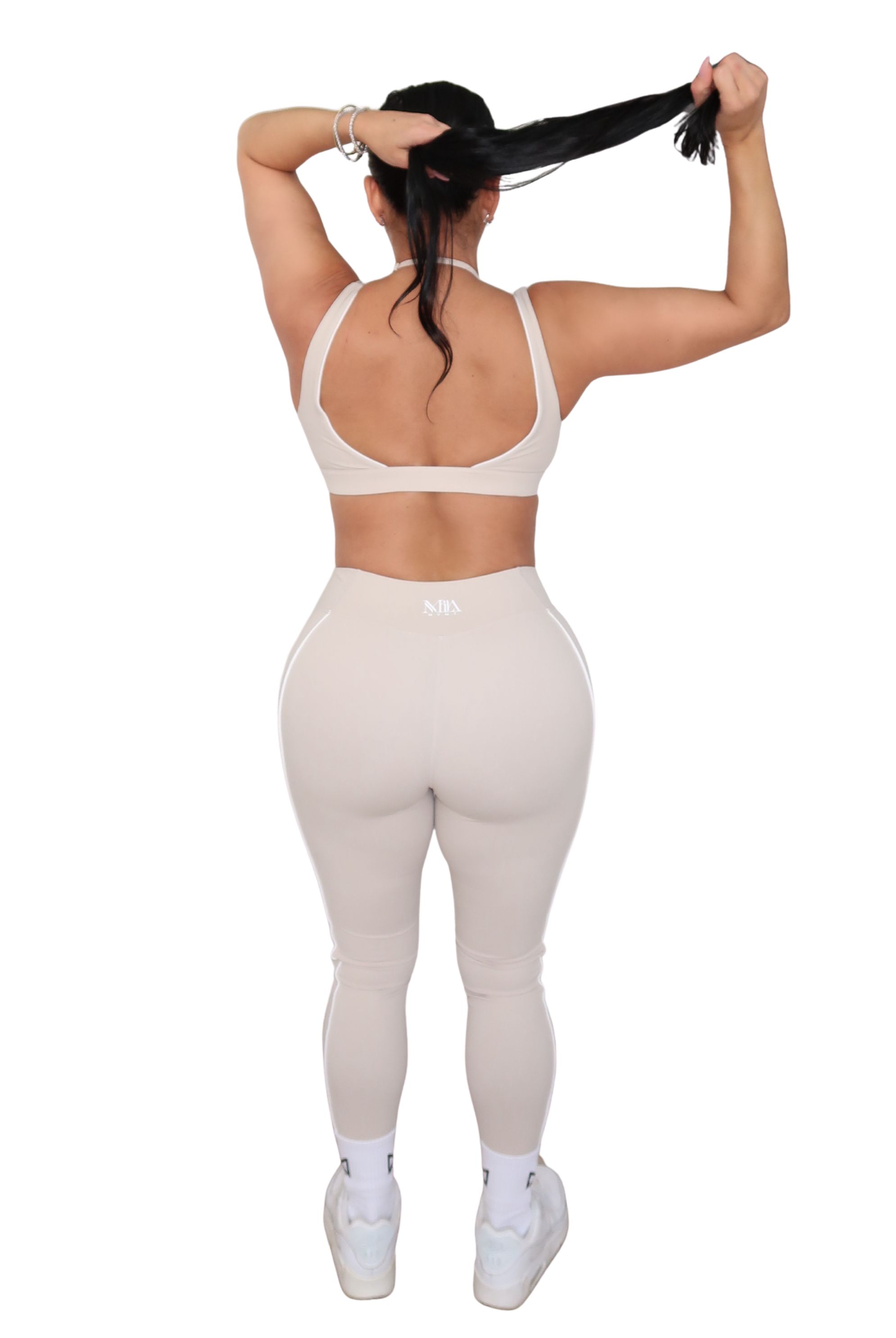 Person wearing a white sports bra and leggings set on a white background