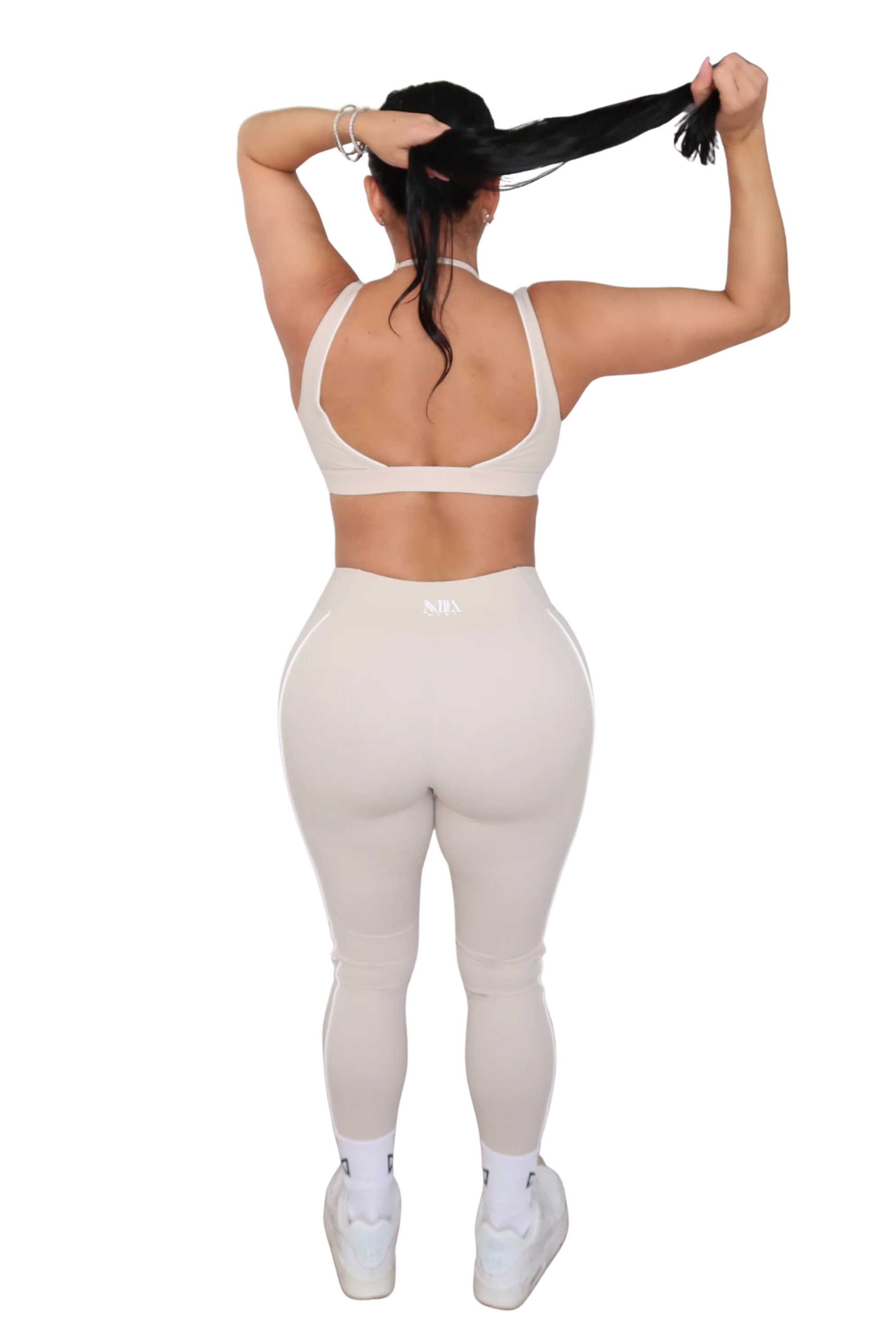Person wearing a white sports bra and leggings set on a white background