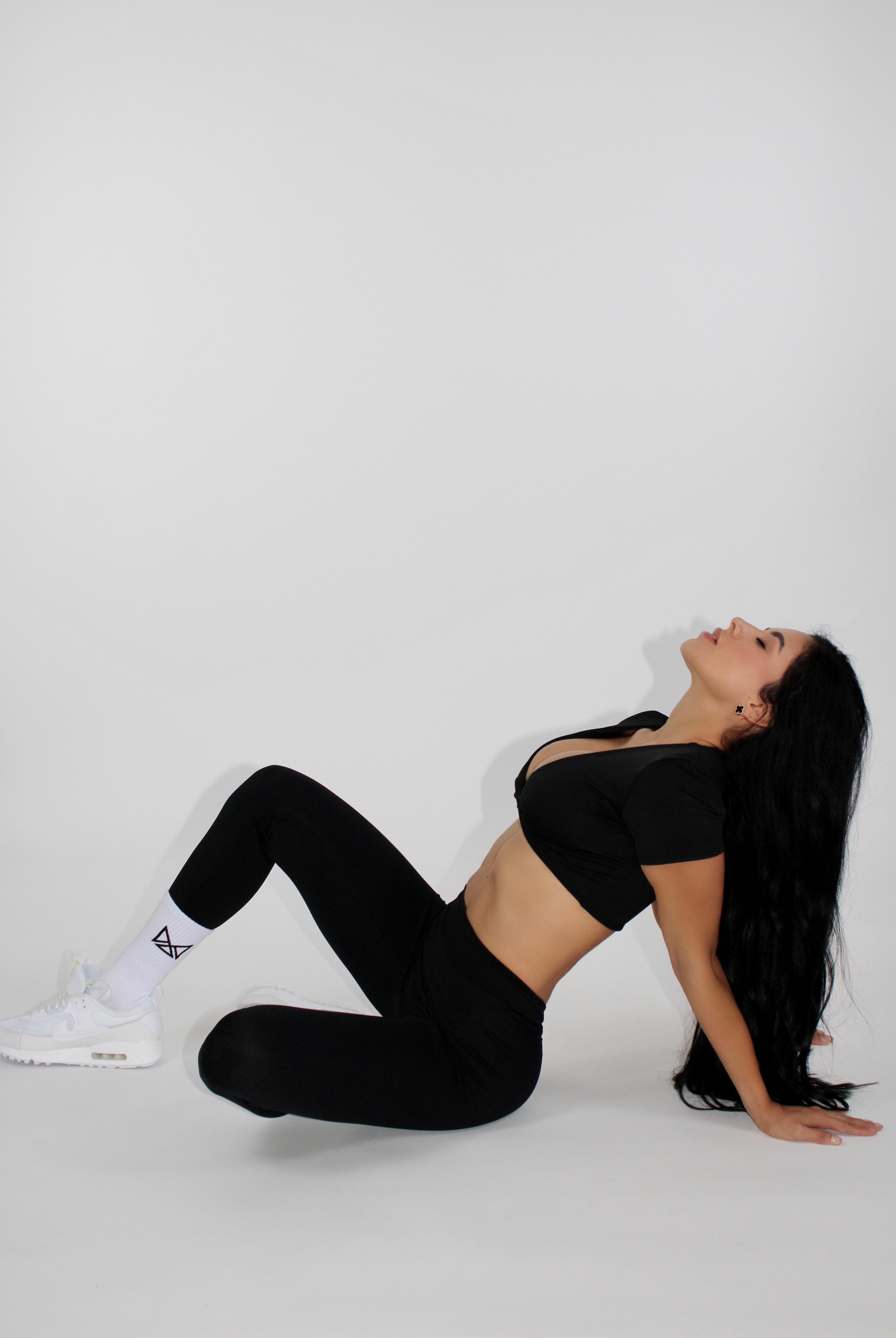 Maia Twist Front Short Sleeve Crop Top Black - Sitting on the floor