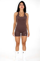 Women wearing a black MILA MVMT Sportswear One-Piece Gym Workout Romper Onesie - facing front