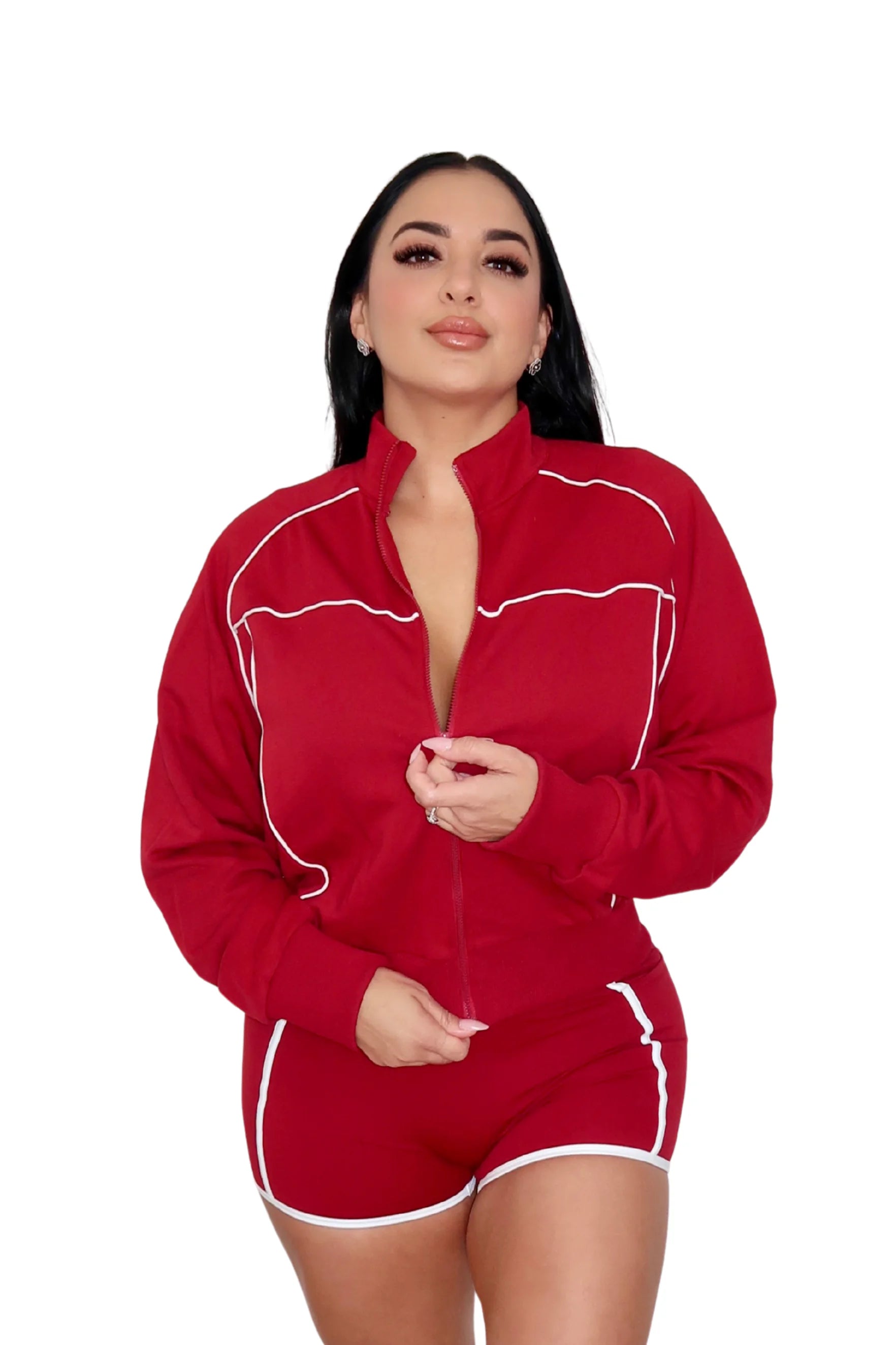 Woman wearing a red athletic outfit with a jacket, sports bra, and shorts on a white background
