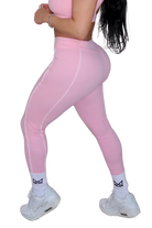 Side view of petal pink leggings on woman by MILA MVMT, mid body legs focus