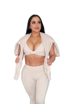 Woman wearing a beige jacket draped over shoulders