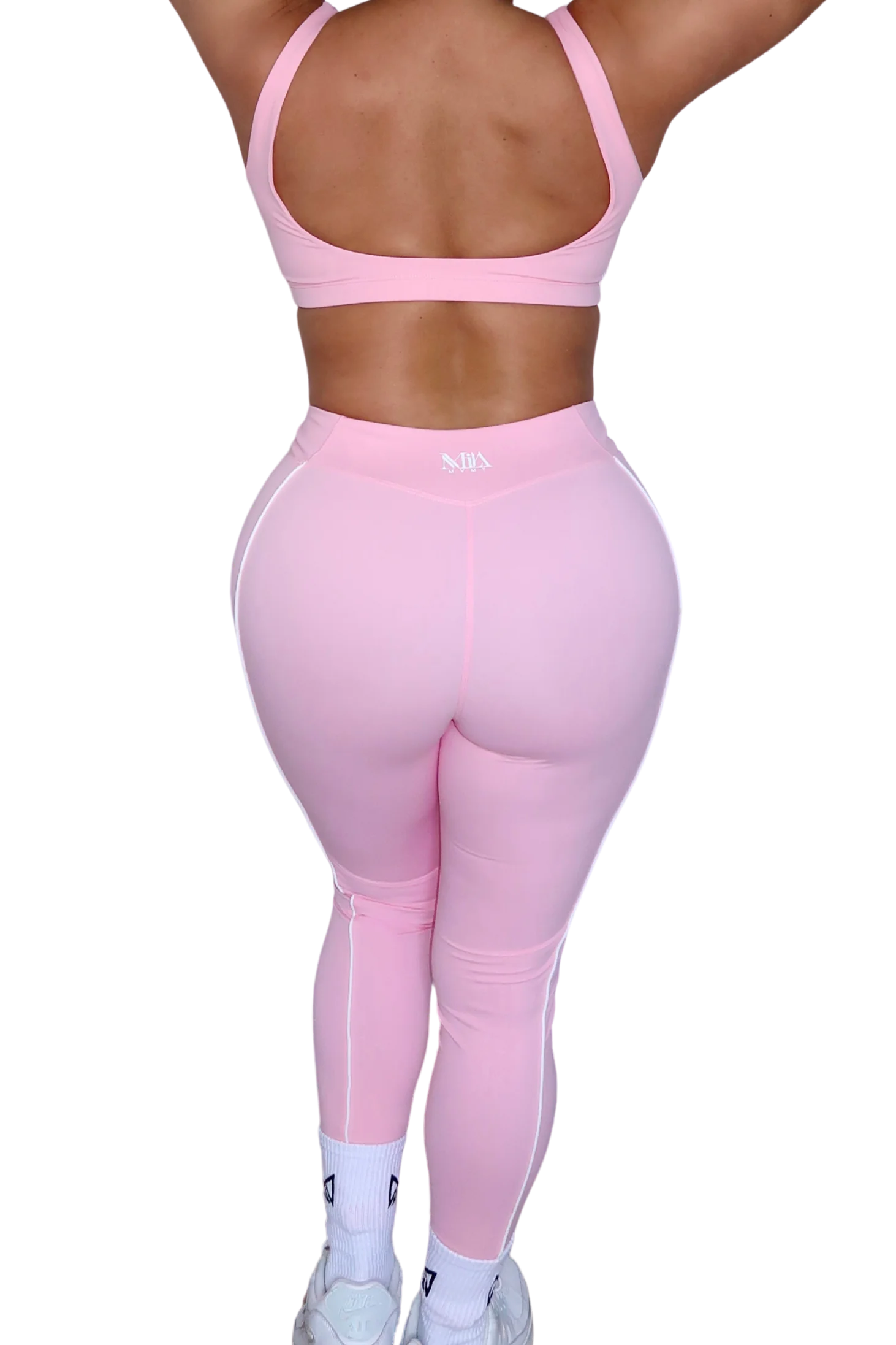 Back view of woman wearing petal pink leggings by MILA MVMT