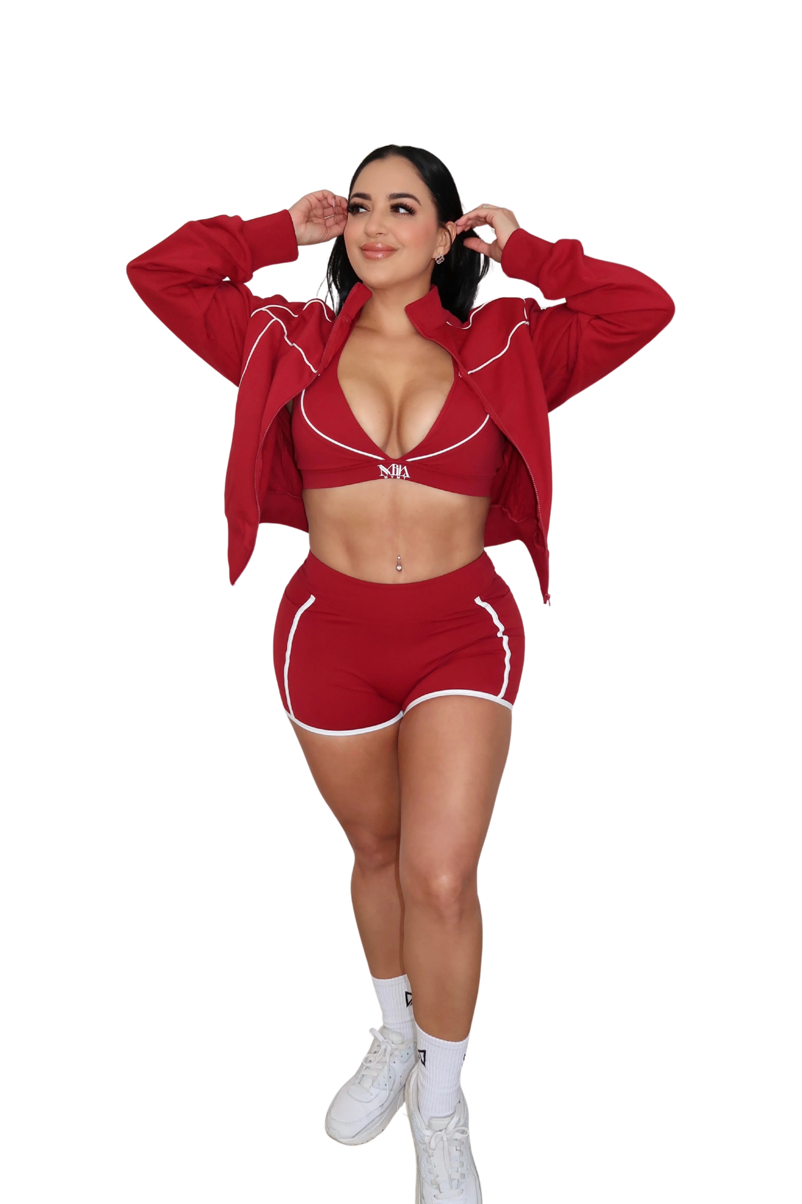 Woman wearing a red outfit with a matching jacket and shorts on a white background