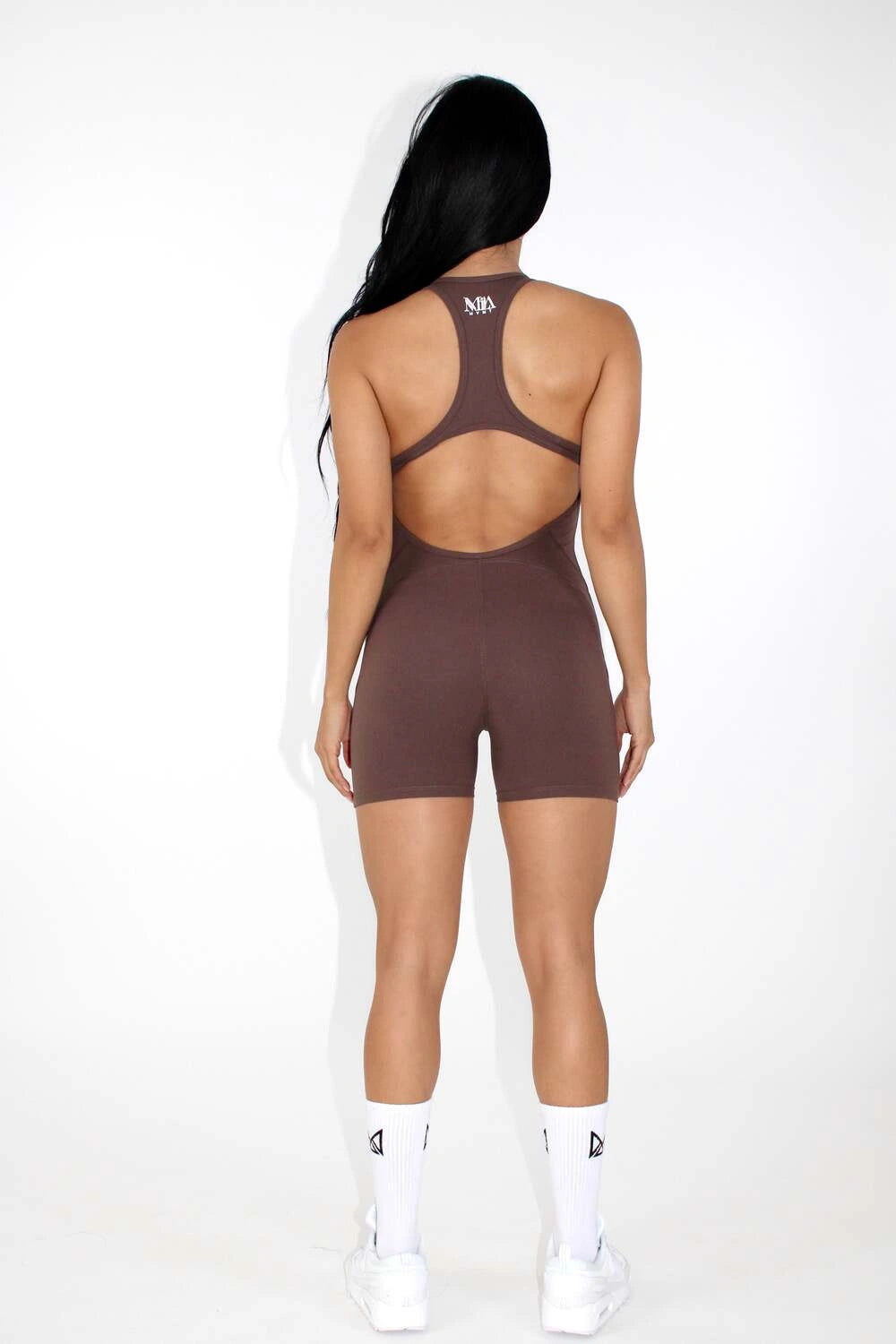 Women wearing a black MILA MVMT Sportswear One-Piece Gym Workout Romper Onesie - facing back
