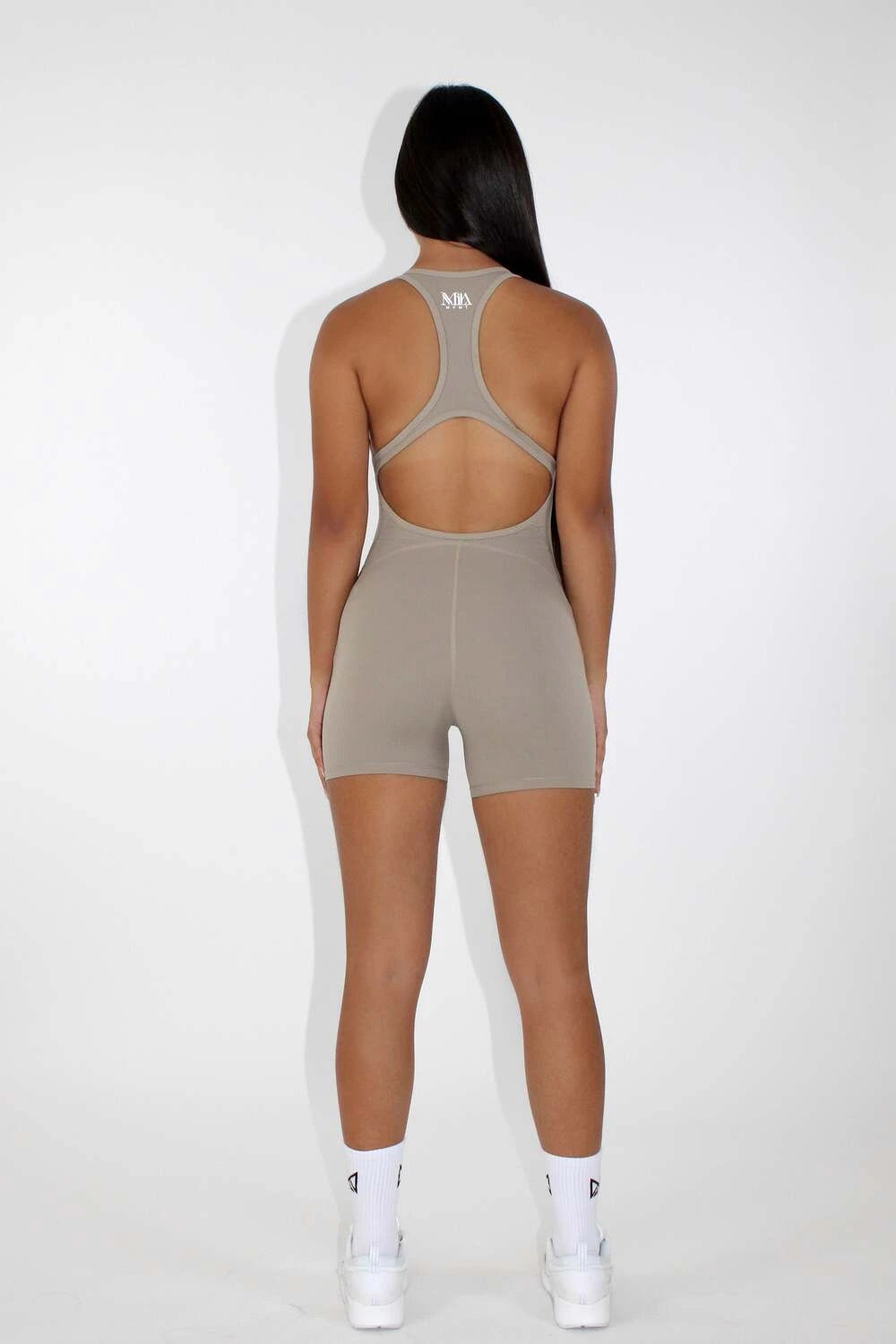 Women wearing a black MILA MVMT Sportswear One-Piece Gym Workout Romper Onesie - facing back