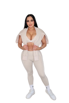Woman in beige athletic wear posing.