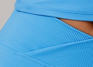 Close-up of a person wearing a blue garment with a plain background