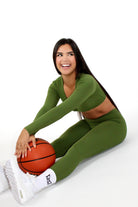 MILA MVMT Sportswear Gym Wear Workout Athleisure Crop Top Long Sleeve fern green color sitting down holding basketball